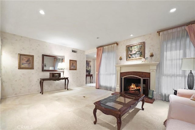 living room featuring a fireplace, light carpet, and a wealth of natural light