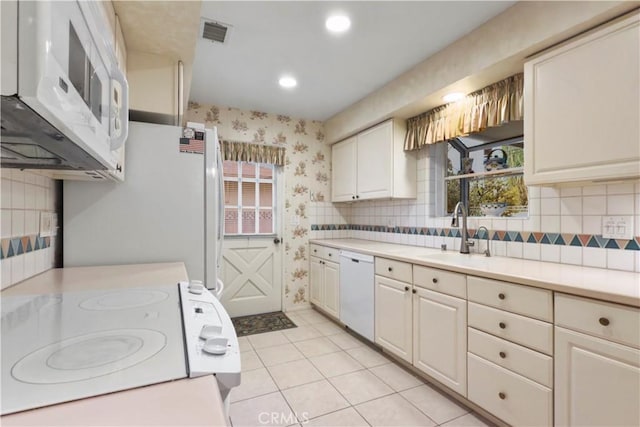 kitchen featuring white cabinetry, white appliances, sink, and light tile patterned floors