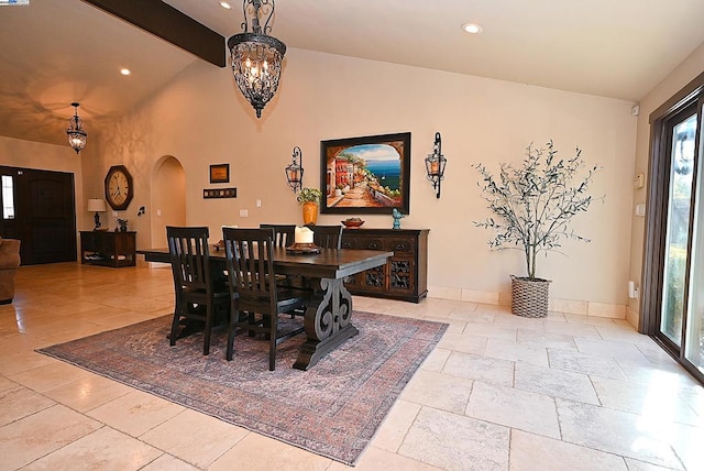 dining area featuring vaulted ceiling with beams and an inviting chandelier