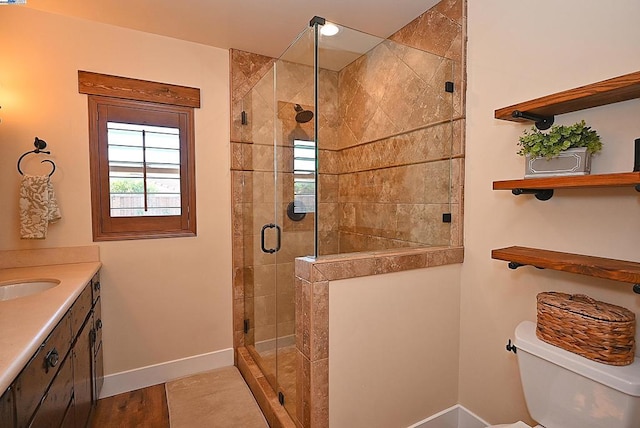 bathroom with walk in shower, vanity, toilet, and wood-type flooring