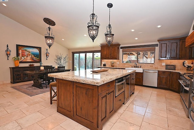 kitchen featuring sink, a center island, vaulted ceiling, hanging light fixtures, and stainless steel appliances