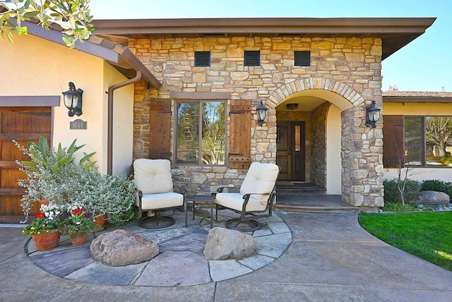 view of exterior entry with an outdoor stone fireplace