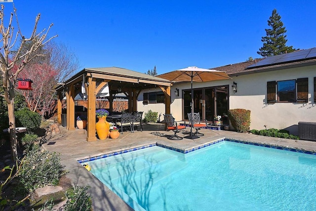 rear view of house featuring a gazebo, a patio, central AC, and solar panels