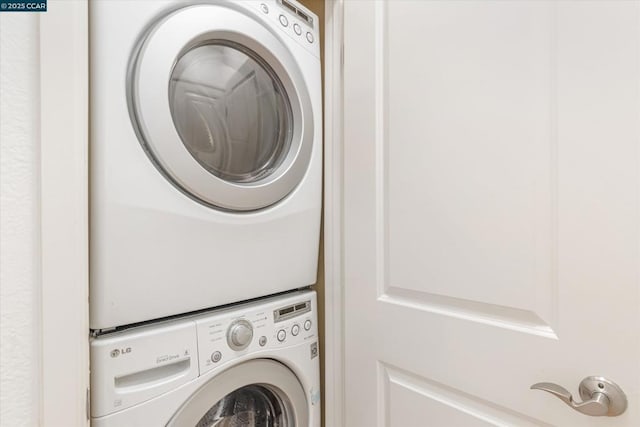 washroom with stacked washing maching and dryer