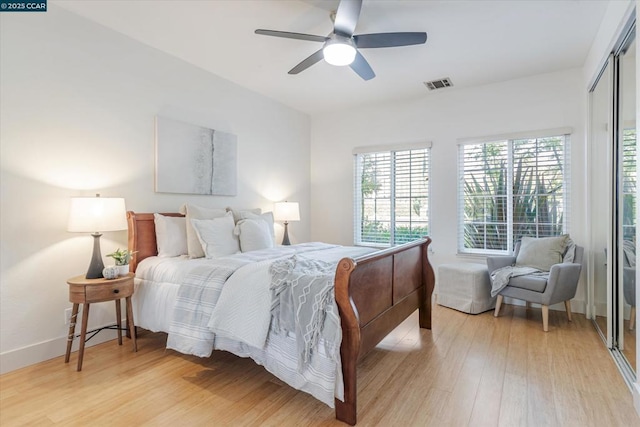 bedroom with light hardwood / wood-style flooring, a closet, and ceiling fan