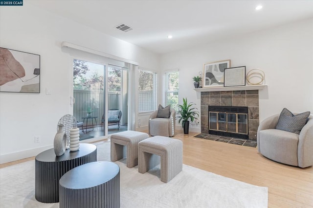 living room with hardwood / wood-style flooring and a tile fireplace