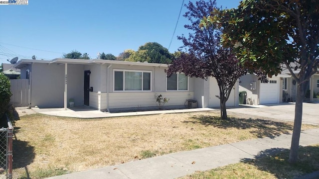 ranch-style house featuring a garage and a front lawn