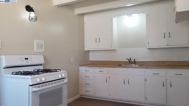 kitchen with white range with gas cooktop, sink, white cabinetry, and decorative backsplash