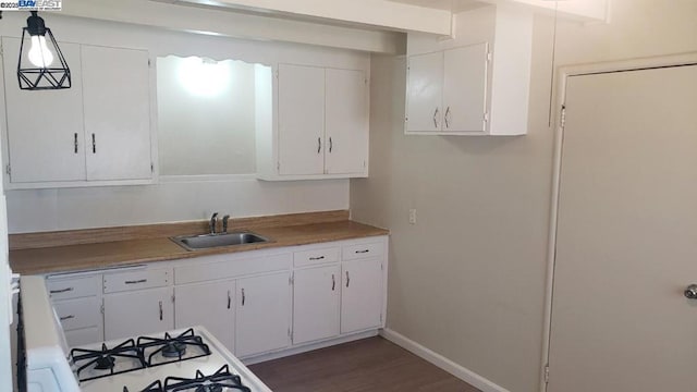 kitchen featuring pendant lighting, sink, dark wood-type flooring, white cabinetry, and white range with gas cooktop