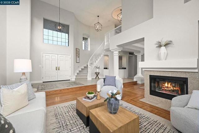 living room with ornate columns, a fireplace, and light wood-type flooring