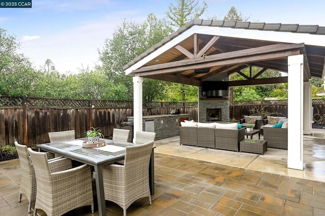 view of patio with a gazebo and an outdoor living space with a fireplace