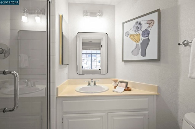 bathroom with an enclosed shower, vanity, and toilet