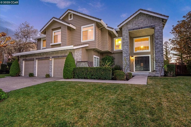 view of front of property with a garage and a lawn