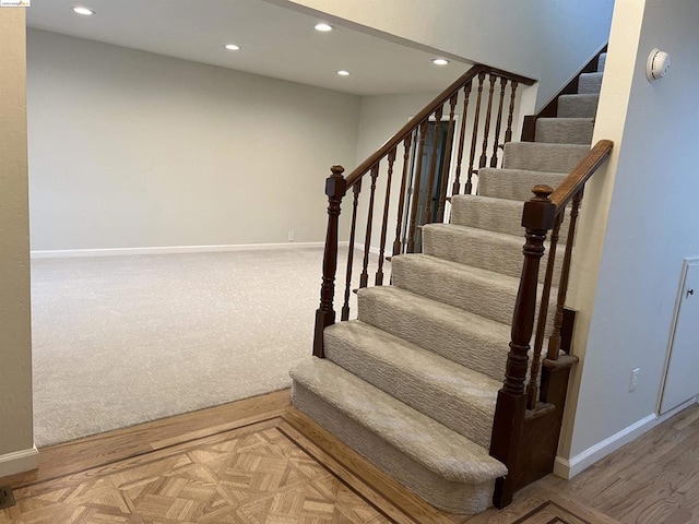 staircase featuring parquet floors