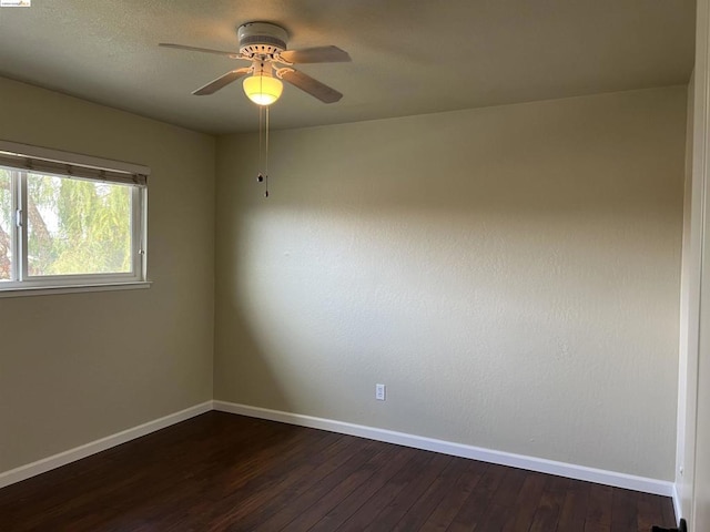 unfurnished room with ceiling fan and dark hardwood / wood-style flooring