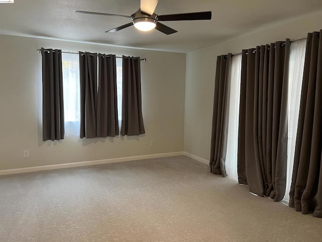 empty room with ceiling fan and carpet floors