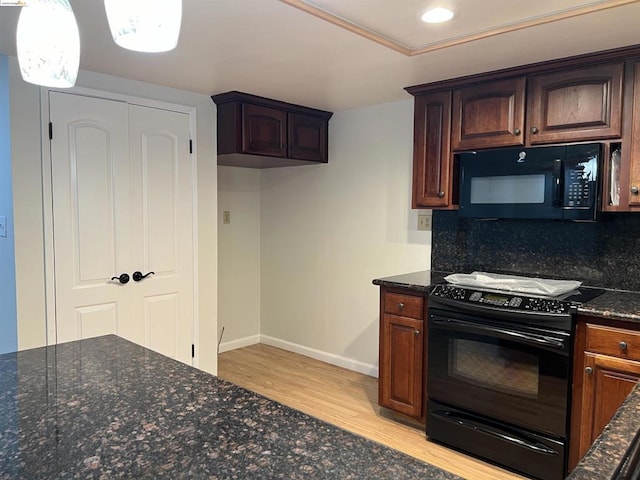 kitchen with tasteful backsplash, dark stone counters, light hardwood / wood-style floors, and black appliances