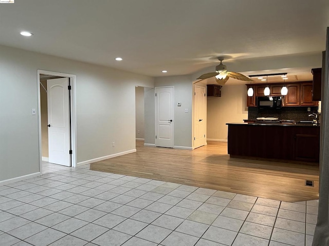 kitchen with light tile patterned floors, sink, ceiling fan, backsplash, and kitchen peninsula