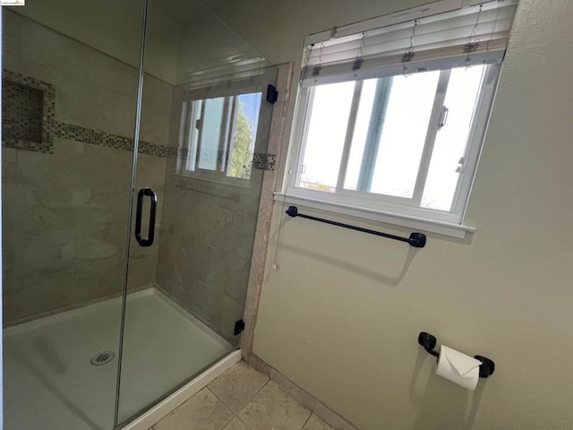 bathroom with an enclosed shower and tile patterned floors