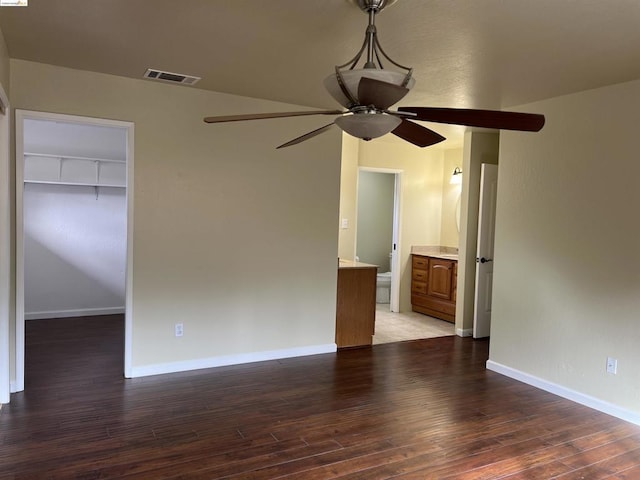 empty room with ceiling fan and dark hardwood / wood-style flooring