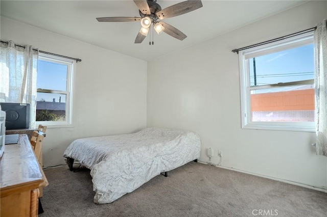 bedroom with ceiling fan, light carpet, and multiple windows