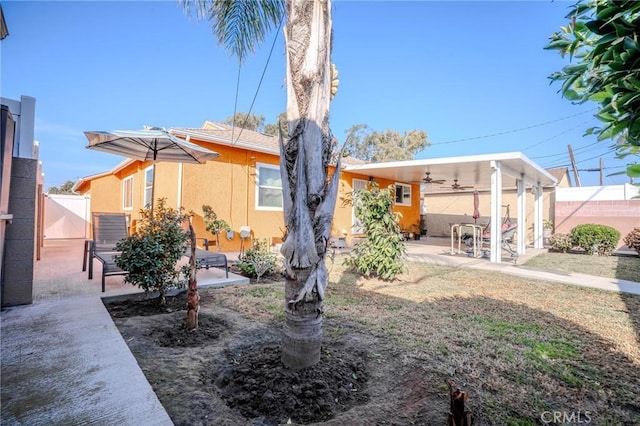 back of property featuring ceiling fan and a patio