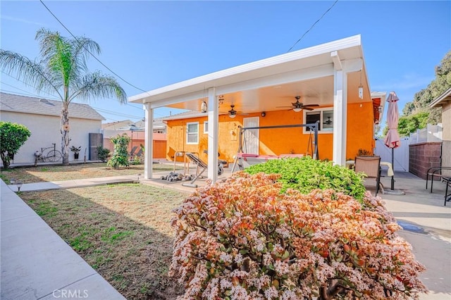 back of property with ceiling fan and a patio