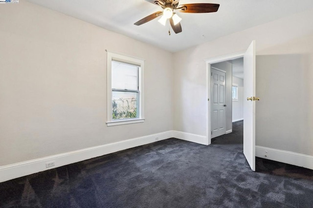 carpeted spare room with ceiling fan