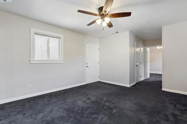 unfurnished room with dark colored carpet and ceiling fan