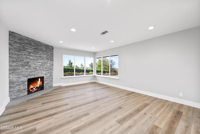 unfurnished living room with a fireplace and light wood-type flooring