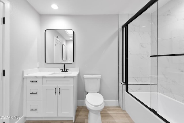 full bathroom featuring toilet, vanity, bath / shower combo with glass door, and wood-type flooring