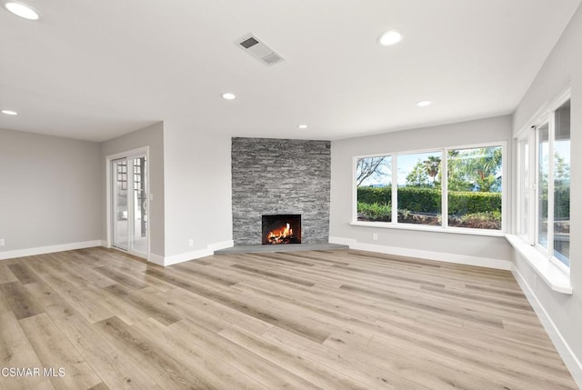 unfurnished living room with a fireplace and light hardwood / wood-style floors