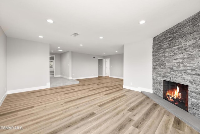 unfurnished living room with a fireplace and light wood-type flooring