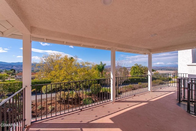 view of patio featuring a mountain view and a balcony