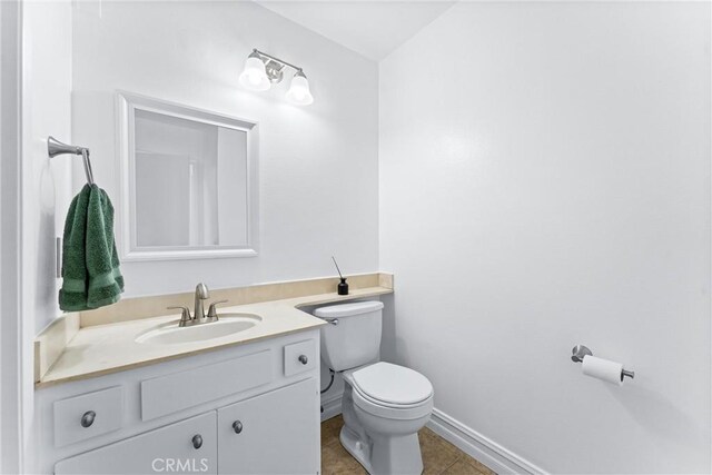 bathroom featuring vanity, tile patterned flooring, and toilet