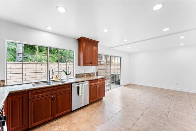 kitchen featuring light stone countertops, sink, stainless steel dishwasher, and light tile patterned floors