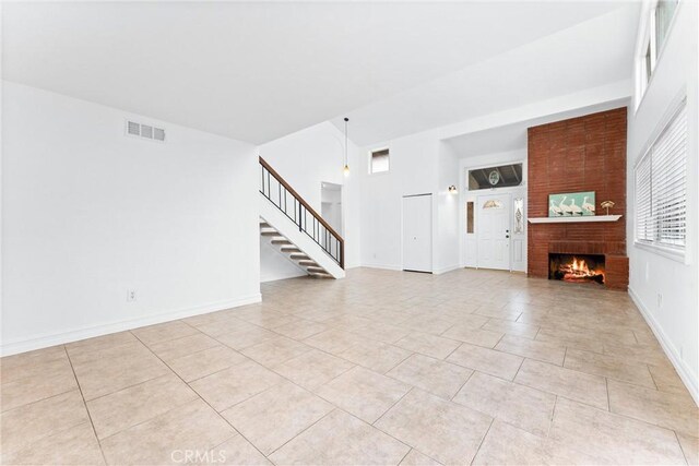 unfurnished living room featuring light tile patterned floors and a fireplace