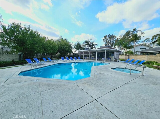 view of pool featuring a hot tub and a patio