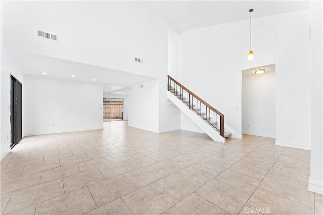 interior space featuring light tile patterned flooring and a high ceiling