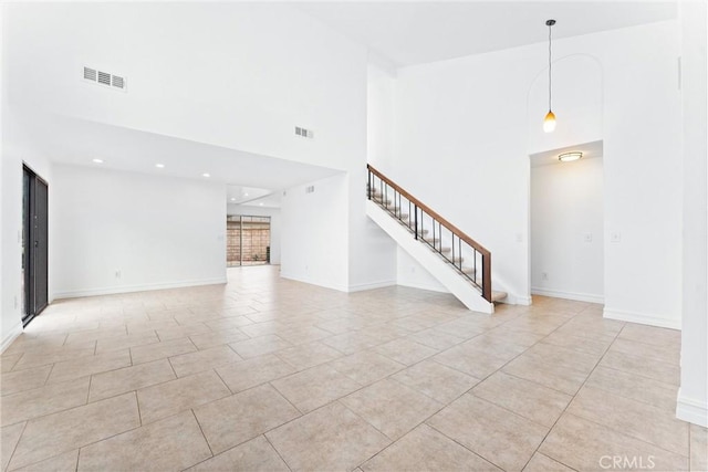 unfurnished living room featuring stairway, light tile patterned flooring, visible vents, and baseboards