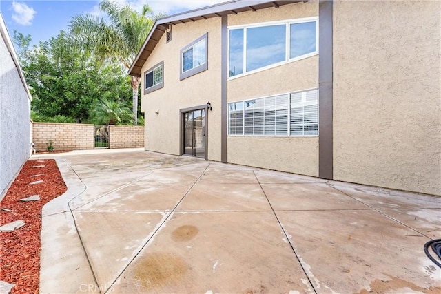 rear view of property featuring a patio area and stucco siding