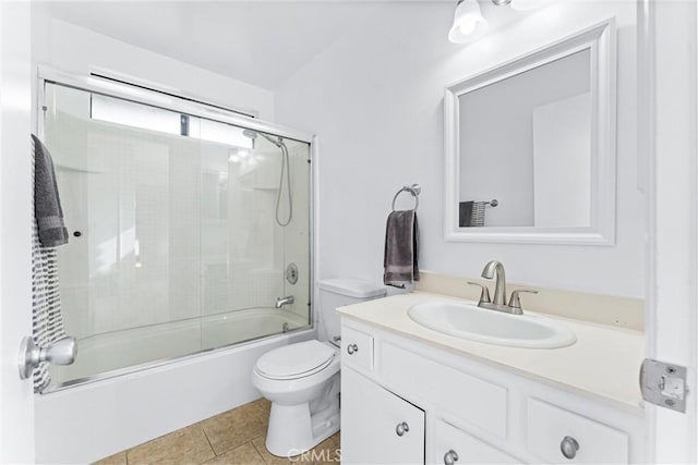 full bath with combined bath / shower with glass door, vanity, toilet, and tile patterned floors