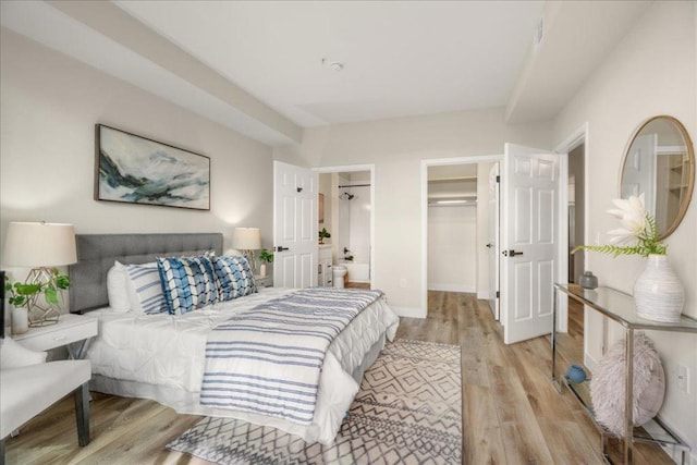 bedroom featuring a spacious closet, light hardwood / wood-style flooring, and a closet