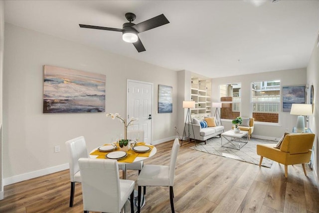 dining space with light hardwood / wood-style flooring and ceiling fan