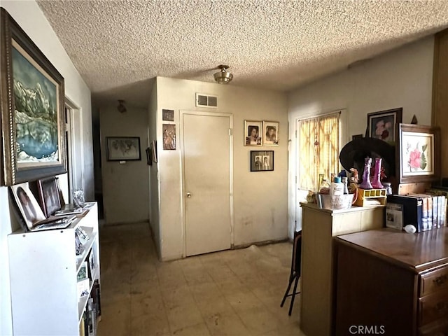 kitchen featuring a textured ceiling and a kitchen breakfast bar