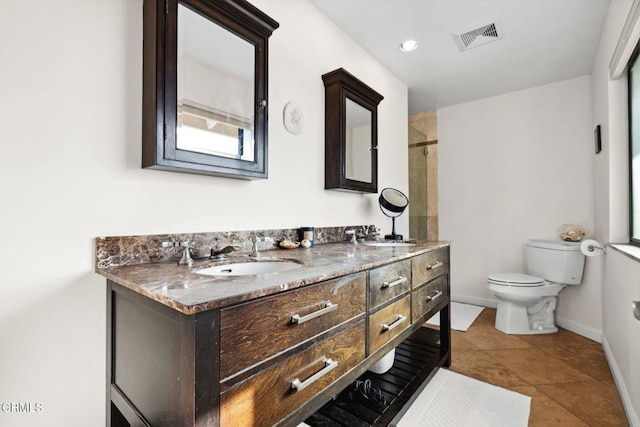 bathroom featuring tile patterned flooring, vanity, toilet, and a tile shower