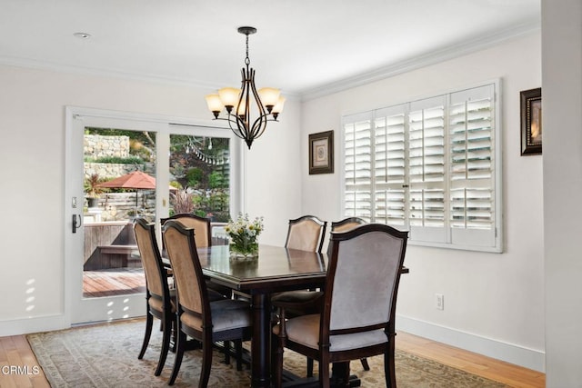 dining room featuring crown molding, a healthy amount of sunlight, and wood-type flooring