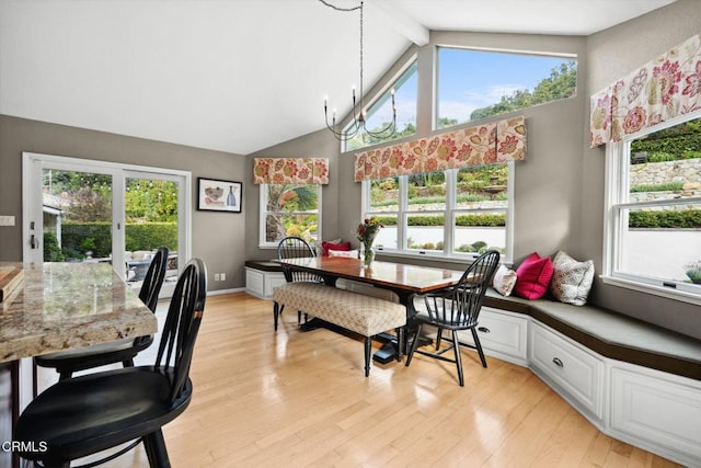 dining room with beamed ceiling, a healthy amount of sunlight, light hardwood / wood-style floors, and a notable chandelier