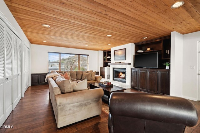 living room with dark hardwood / wood-style flooring, built in shelves, a fireplace, and wooden ceiling