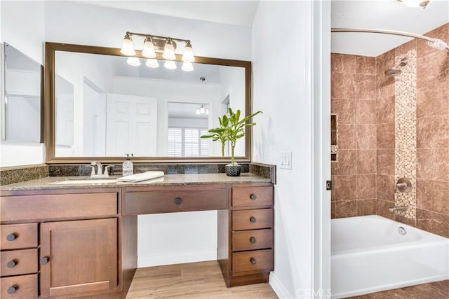 bathroom with vanity, hardwood / wood-style floors, and tiled shower / bath